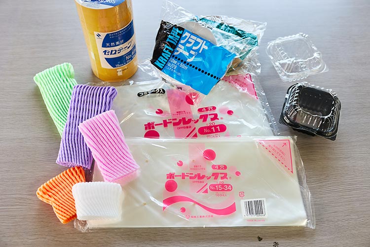 袋に入った野菜や果物が店頭に並んでいるイメージ