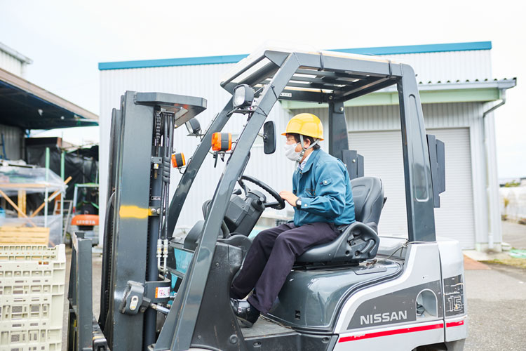 農産物が入ったコンテナやパレットが倉庫に並んでいる様子